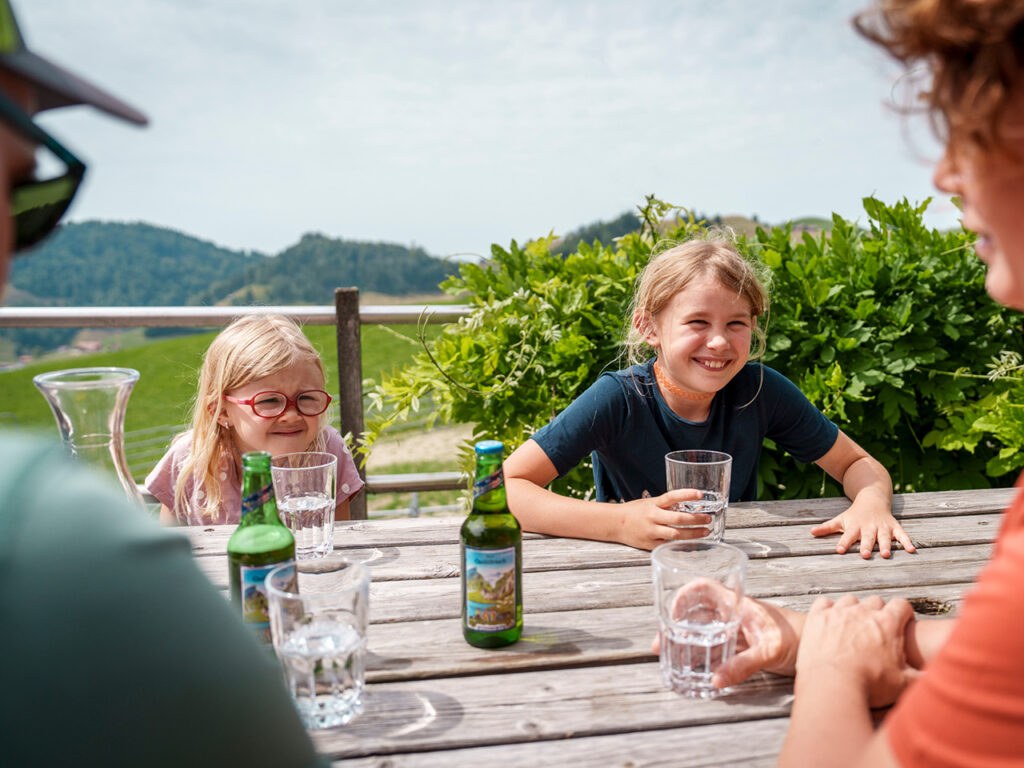 Ferienwohnung Ausstattung - Familie auf der Terrasse der Ferienwohnung auf dem Bauernhof mit Blick ins Neckertal